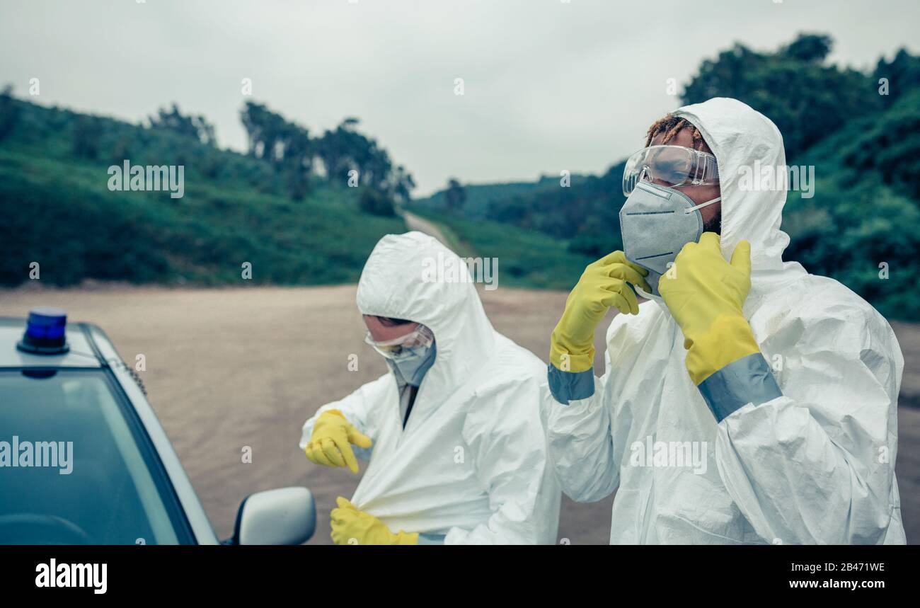 Two young people putting on bacteriological protection suits Stock Photo