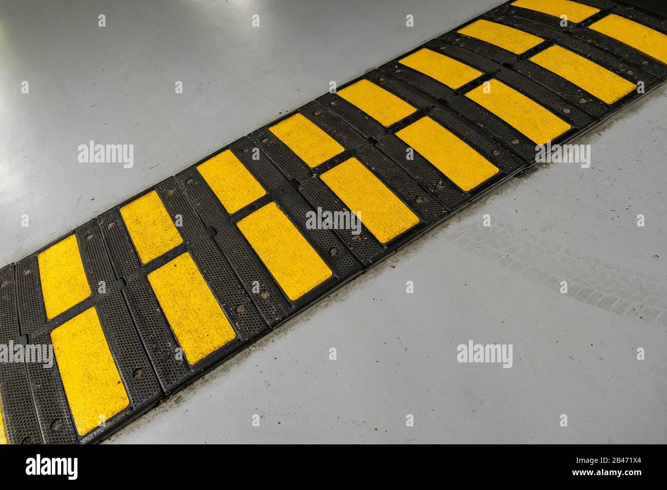 Striped black and yellow speed bump on a road Stock Photo Alamy