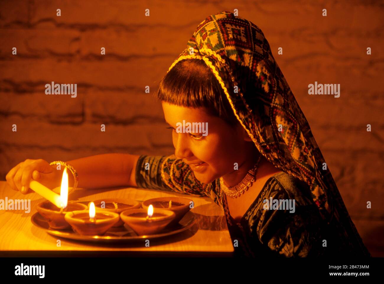 Girl lighting oil lamps on Diwali Festival, India, Asia, MR#201 Stock Photo