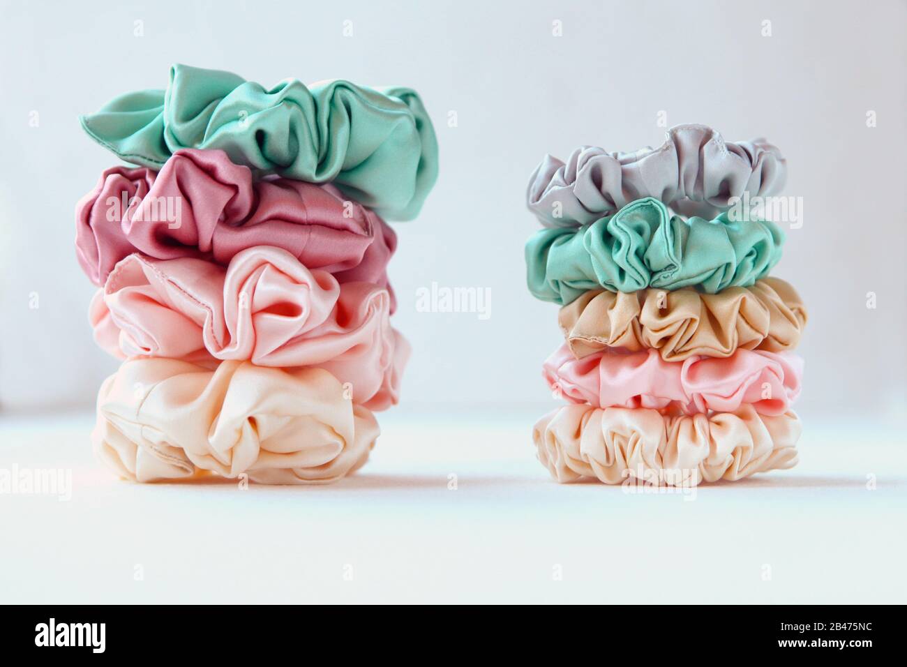 Lot of Colorful silk Scrunchies on white. Luxury Hairdressing tools and accessories. Hair Scrunchies, Elastic HairBands, Bobble Sports Scrunchie Stock Photo