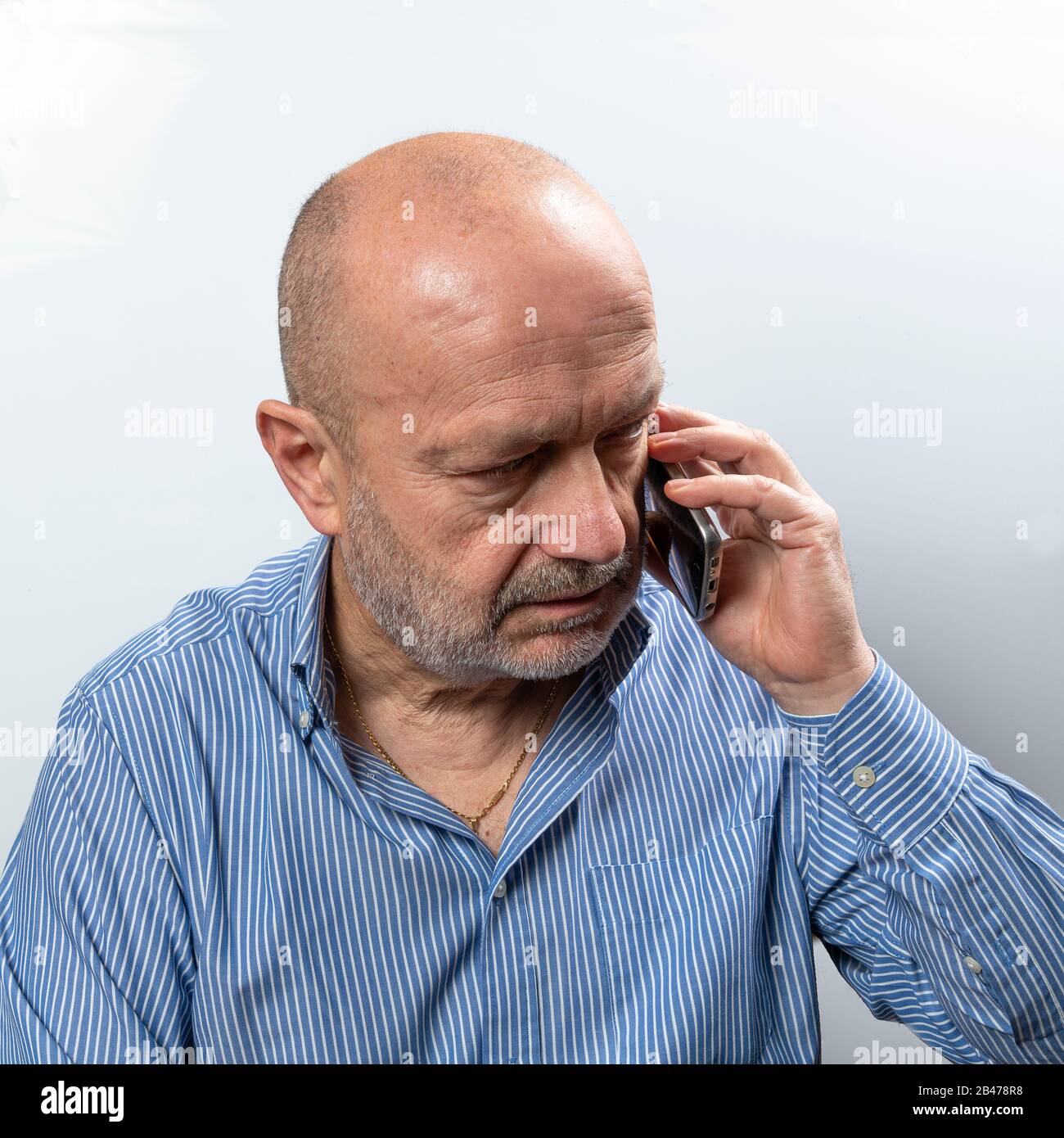 A middle-aged man argues during a cell phone conversation Stock Photo