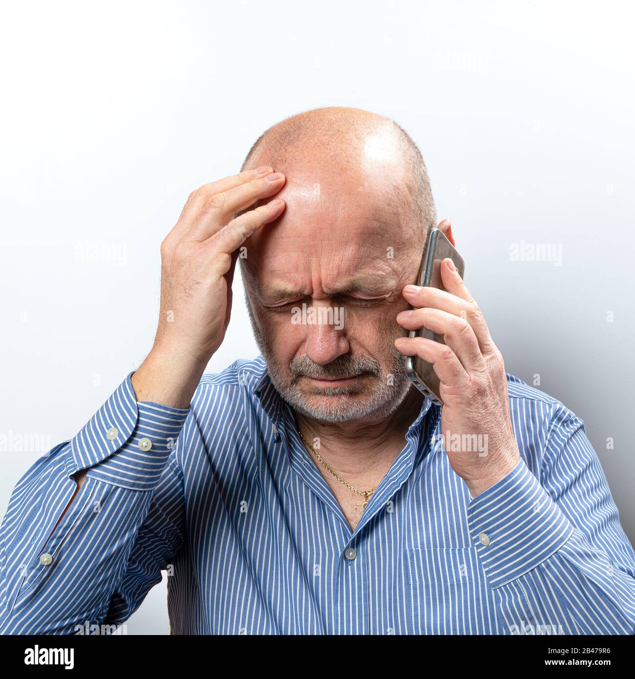 A middle-aged man worried while talking on a cell phone Stock Photo