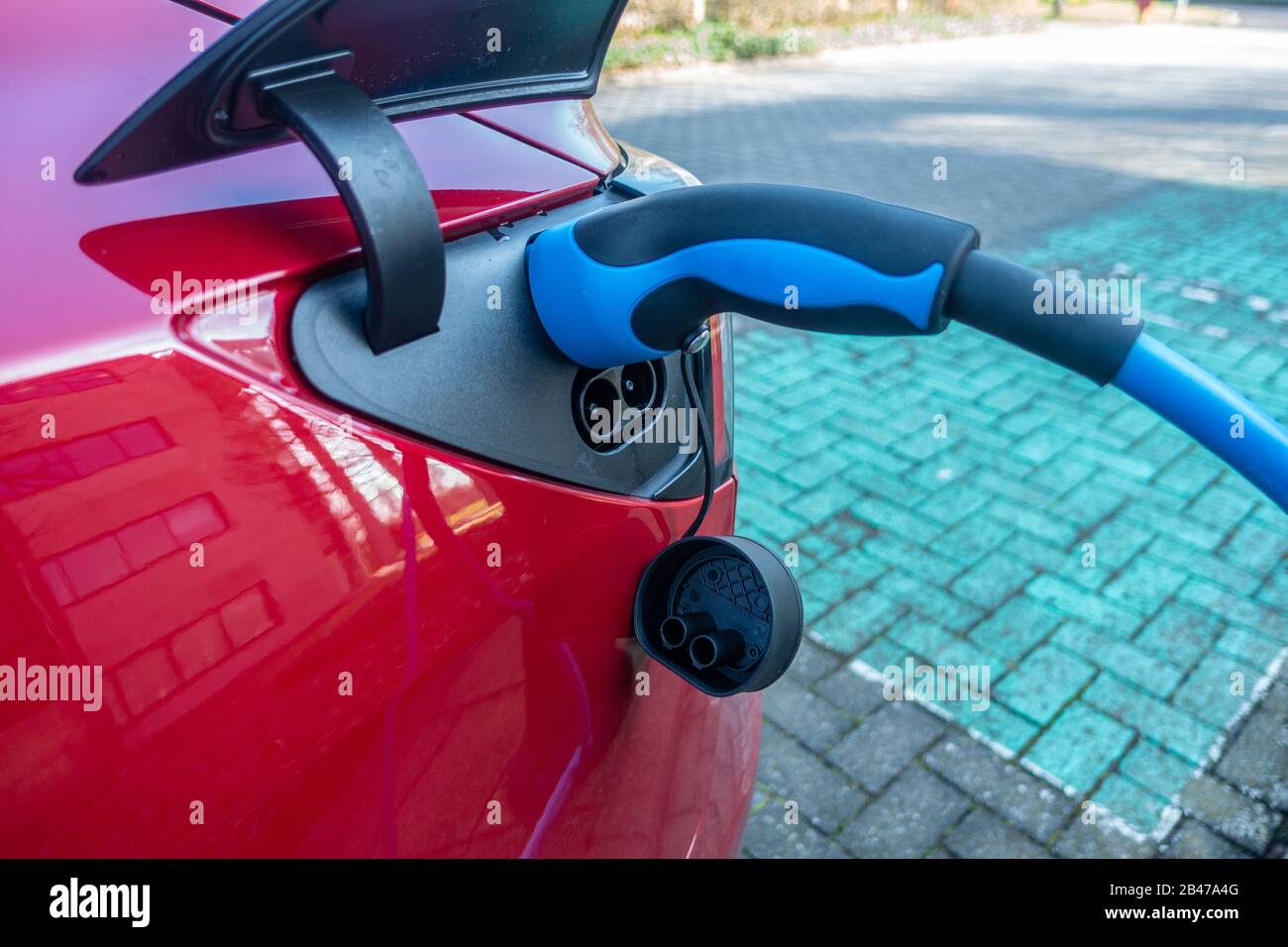 An electric car plugged into a charging point to charge Stock Photo Alamy