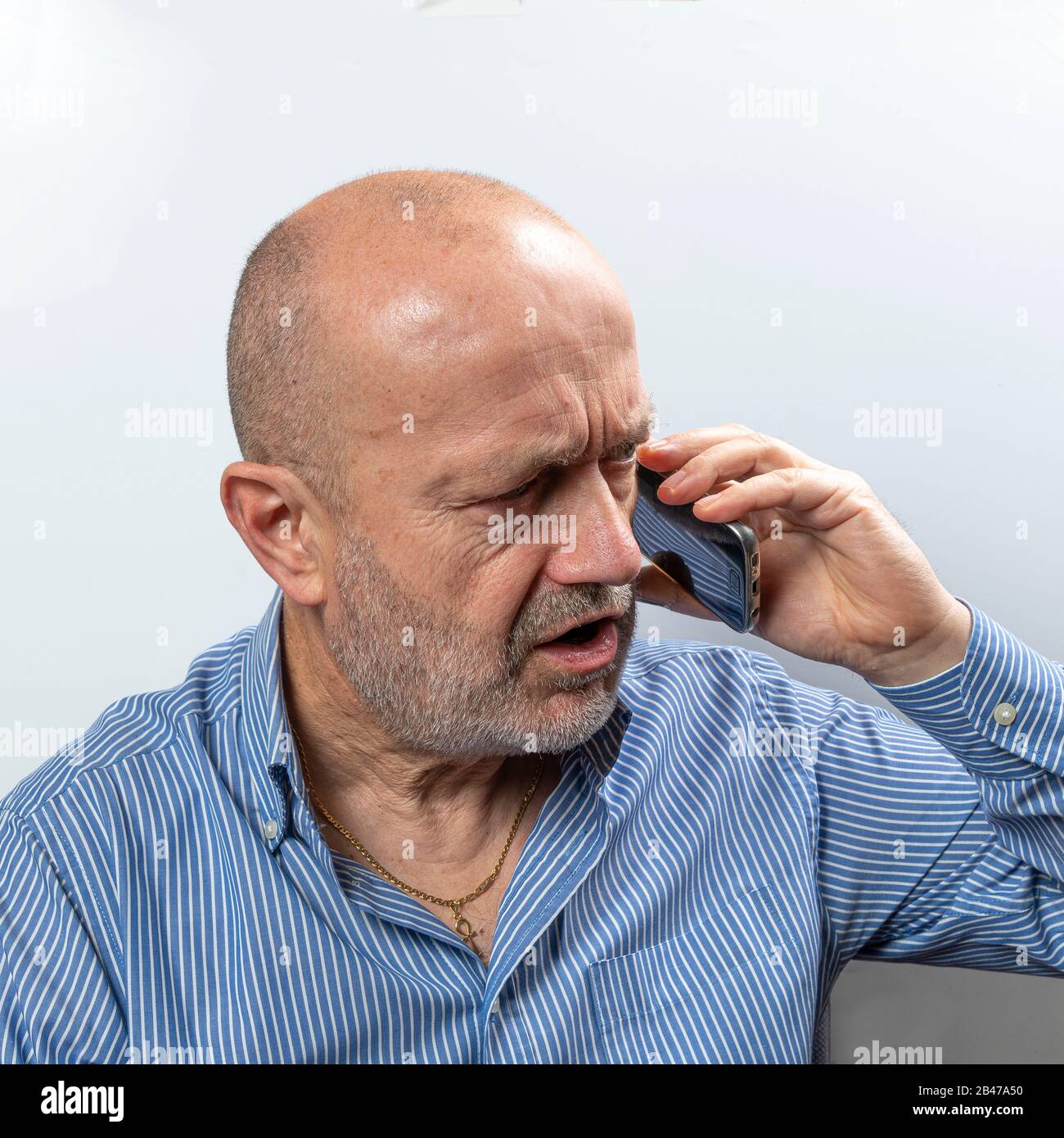 A middle-aged man argues during a cell phone conversation Stock Photo