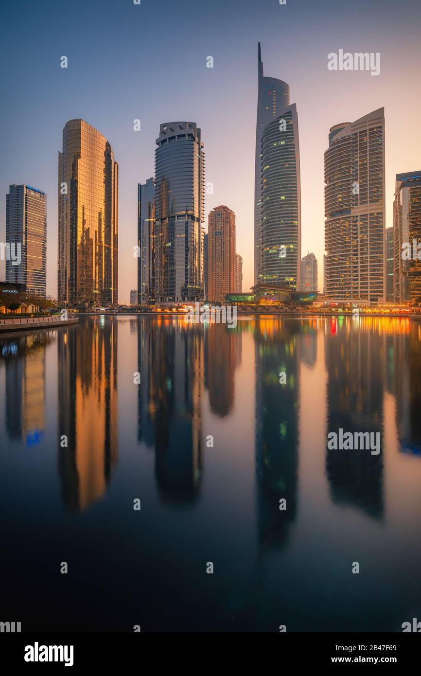 Amazing architecture parallel buildings. Cloudy night sky. Luxury travel inspiration. Dubai Jumeirah Lake Towers. Stock Photo