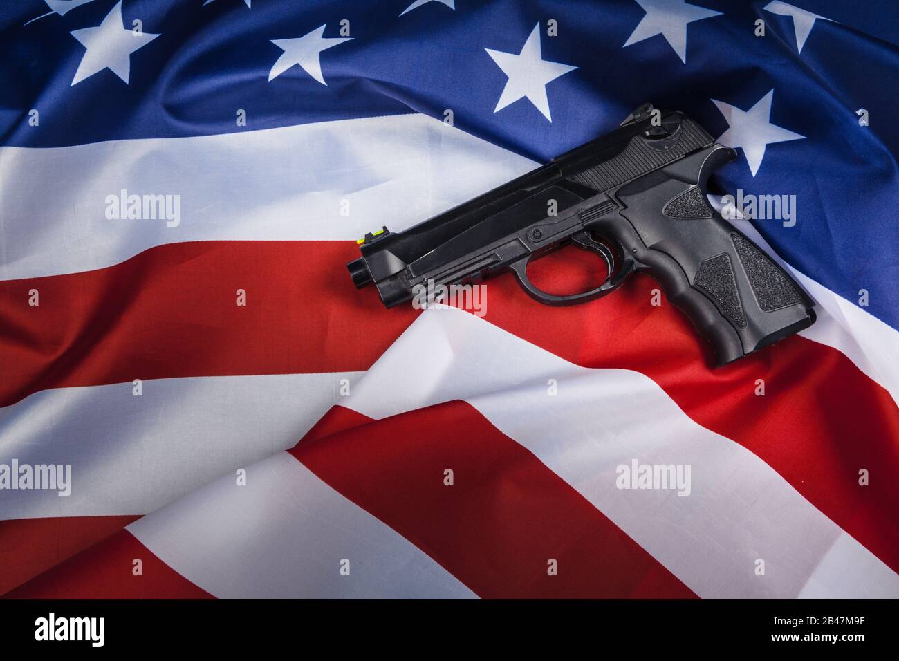 Handgun lying on American flag. Weapon problem concept Stock Photo