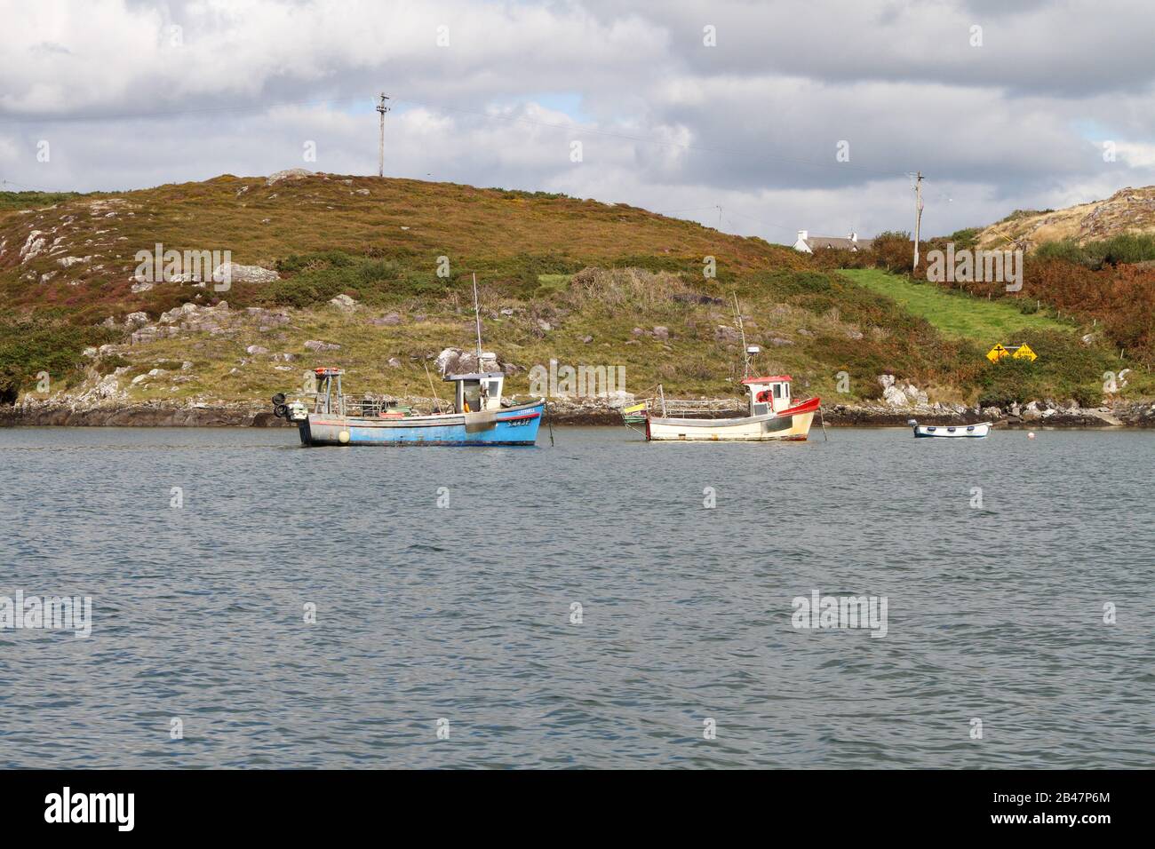 Autumn in Roaringwater Bay with three small fishing boats moored in a row in descending size off