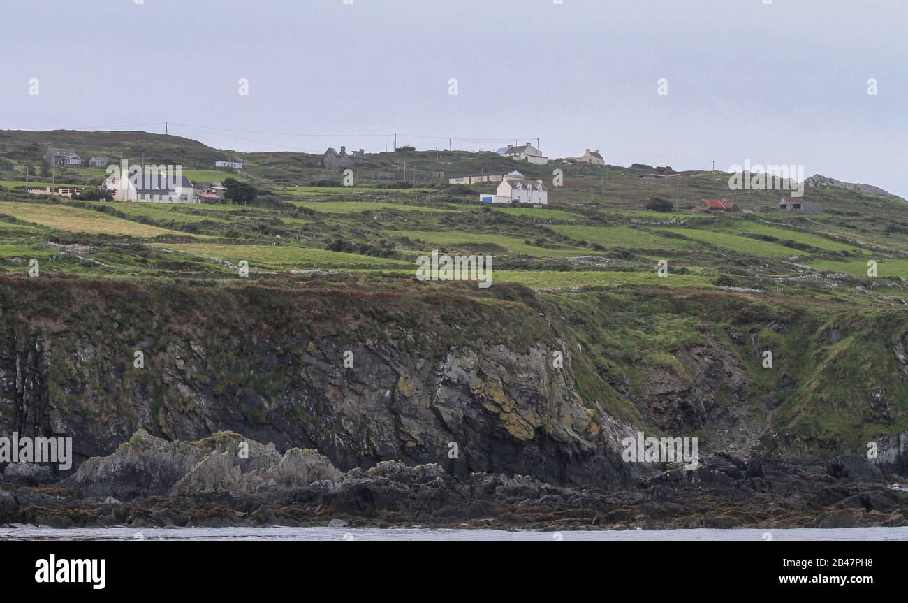 White coloured houses and small fields above coastal cliffs on north