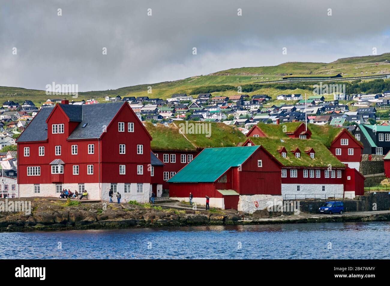 Denmark, Tinganes peninsula , Torshavn, Streymoy, Faroe Islands. Tinganes is the historic location of the Faroese landsstýri (government), and is a central part of Tórshavn. The name Tinganes means 'parliament jetty' or 'parliament point' in Faroese. Many of the wooden houses on Tinganes were built in the 16th and 17th centuries and have the typical red color as well as grass roof, that is very common on the Faroe Islands. Stock Photo