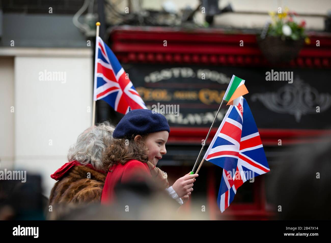 A young fan of The Duke & Duchess of Cambridge waves flags outside Tig Cóilí  Bar in Galway City, Ireland where the Royal Couple visited. Stock Photo
