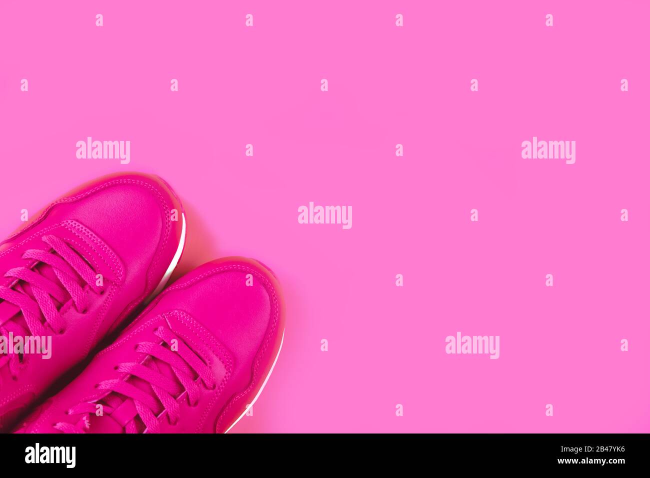 Bright pink sneakers on pink background. Concept of woman sport and healthy lifestyle in monochrome. Place for text, flat lay, top view. Stock Photo