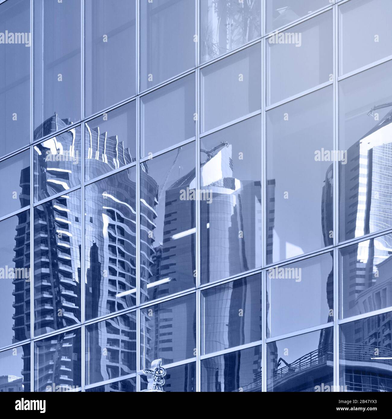 Reflection of modern towers in the glass wall of skyscrapers