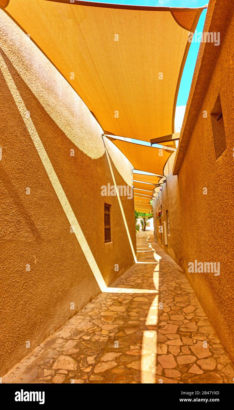 Perspective of traditional arabian street with fabric awnings in Al Fahidi Historical Neighbourhood in Old Dubai, United Arab Emirates (UAE) Stock Photo