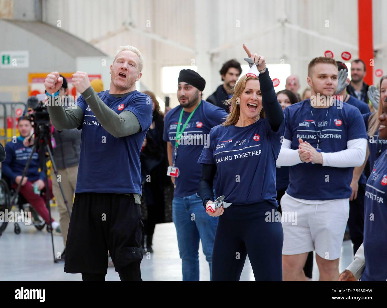 Iwan Thomas (left) and Gabby Logan wait to join members of staff in an attempt to break the Guinness World Record for the heaviest 100m A350 plane pull during a Sport Relief event at Heathrow Airport in London. Stock Photo