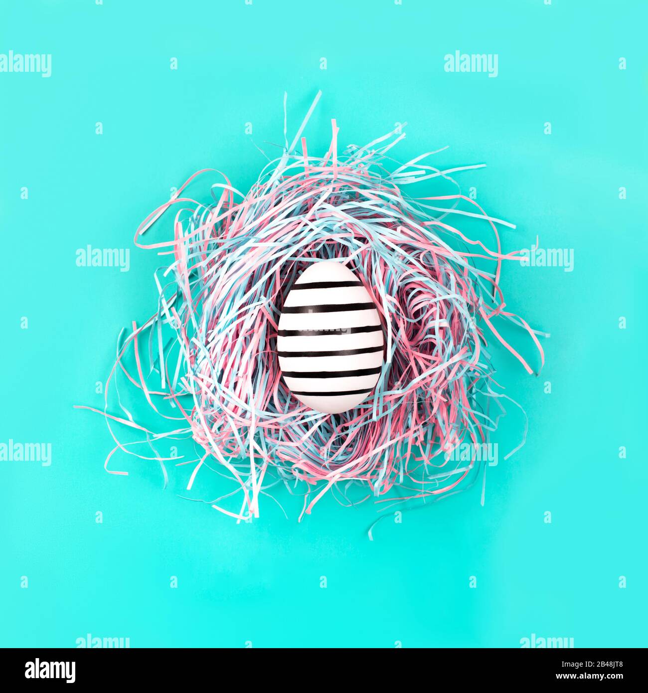 Graphic hand-painted in line egg in decorative nest on blue pastel background. Easter concept. Stock Photo
