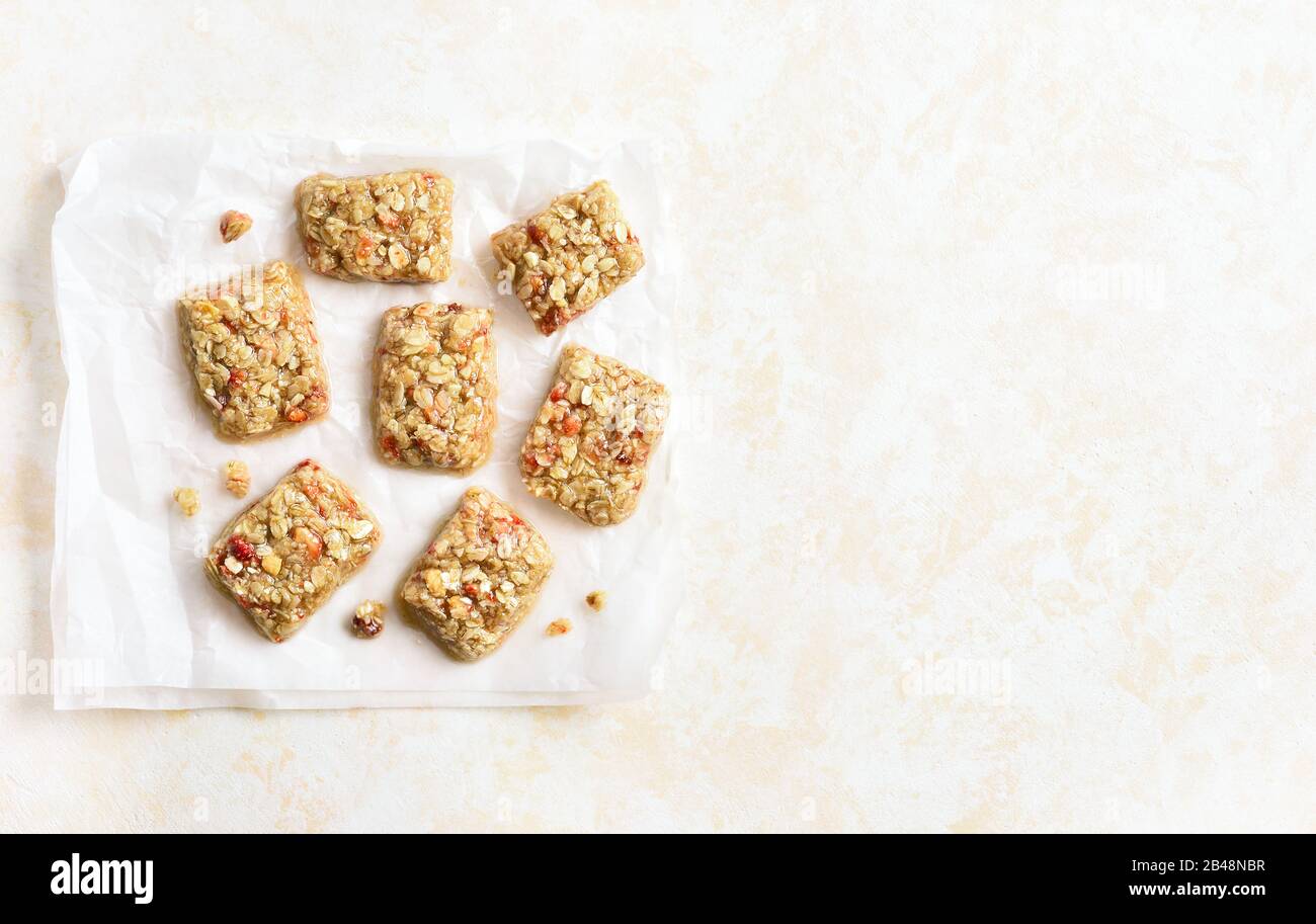 Honey no baked granola bar on paper over light stone background with free space. Top view, flat lay Stock Photo