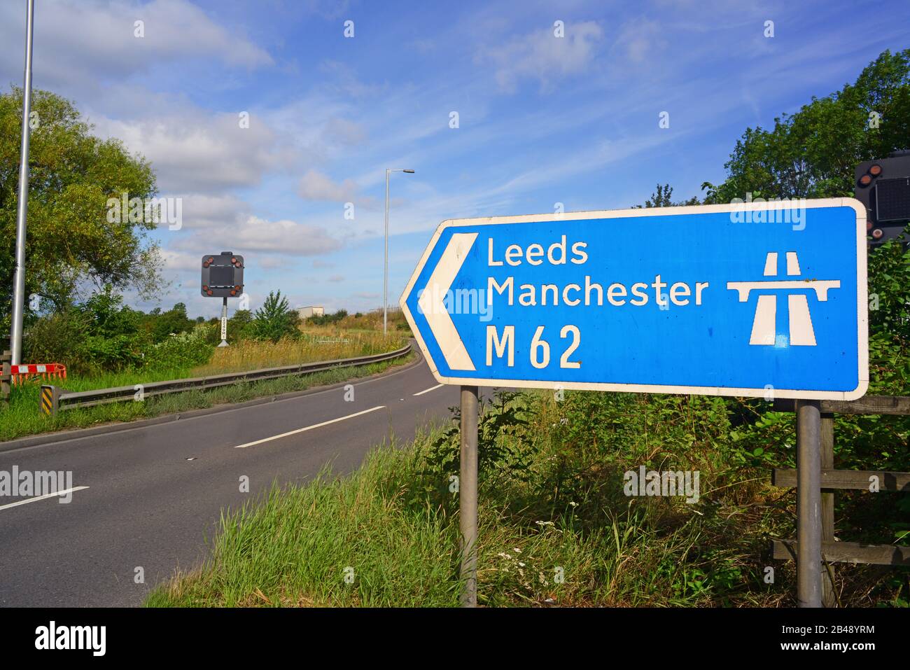 traffic passing m62 motorway sign to leeds and manchester at normanton junction leeds yorkshire uk Stock Photo