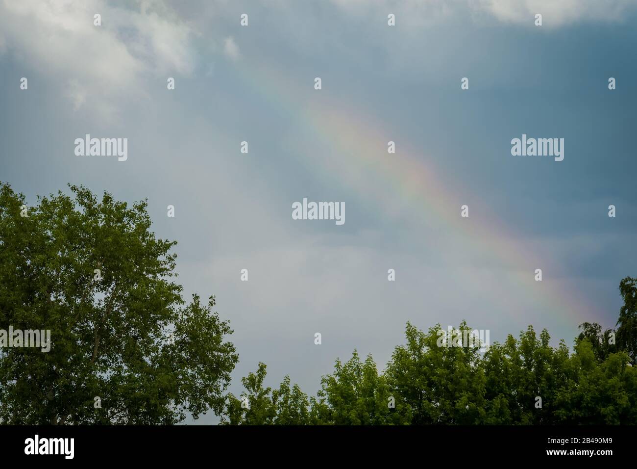 Dark rain clouds and colorful rainbow in the sky background Stock Photo ...