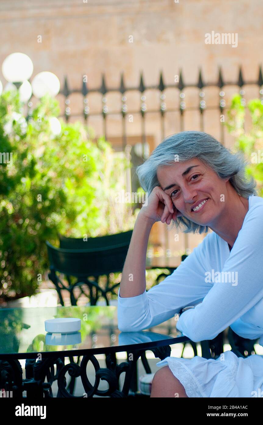 Portrait of mature woman sitting on a terrace Stock Photo - Alamy