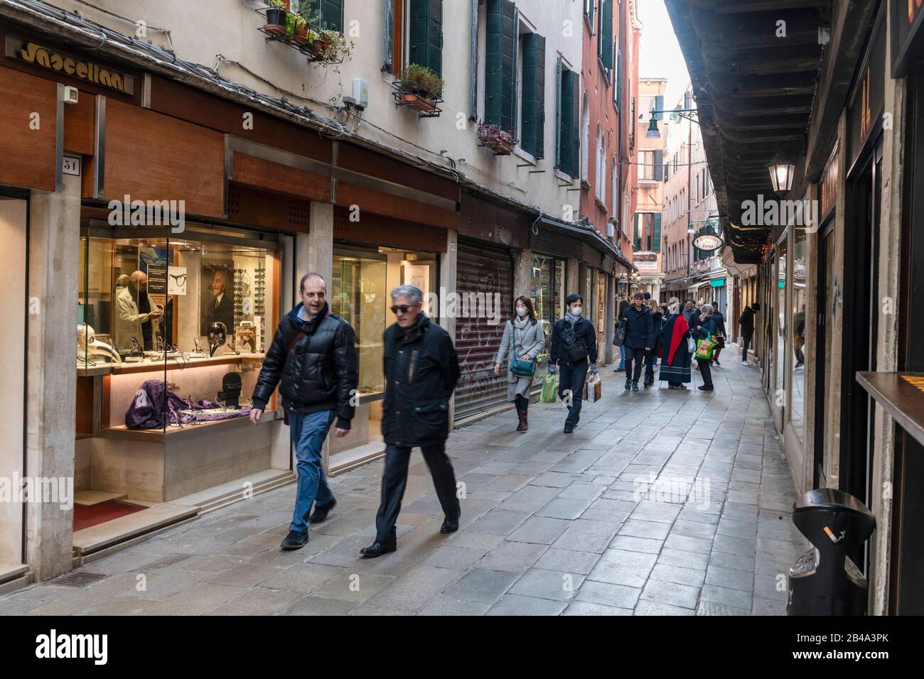 Venice, February 25th - March 3rd. 2020: Venice streets deserted due to Coronavirus pandemic. Piazza's and streets are empty apart from a handful of tourists and locals going about their daily business. Nany tourists cancel their visit for fear of catching the virus. Tourists from Japan and other far eastern countries like Taiwan  often wear surgical masks as a preventative measure. Stock Photo