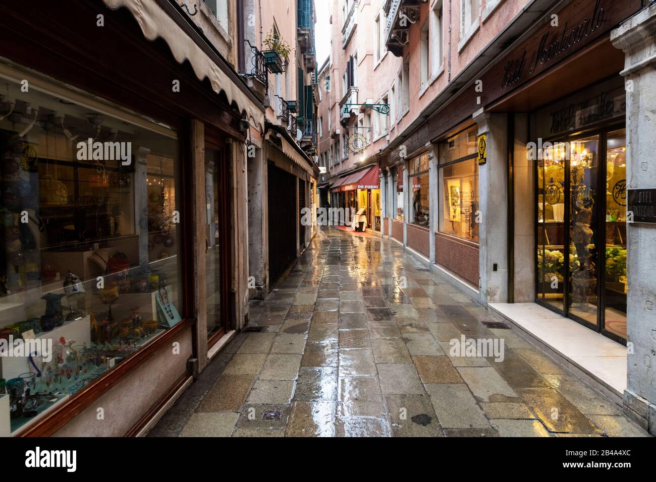 Venice, February 25th - March 3rd. 2020: Venice streets deserted due to Coronavirus pandemic. Piazza's and streets are empty apart from a handful of tourists and locals going about their daily business. Many tourists cancel their visit for fear of catching the virus. Tourists from Japan and other far eastern countries like Taiwan  often wear surgical masks as a preventative measure. Stock Photo