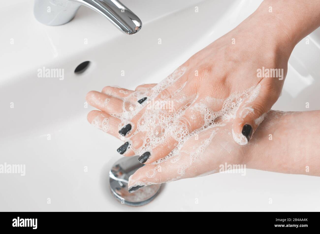 Effective handwashing techniques: woman wash her hands using palm to palm technique. Hand washing is very important to avoid the risk of contagion fro Stock Photo