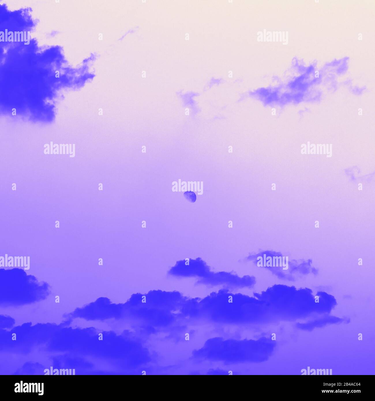 Moon behind the clouds, violet blue toned Stock Photo