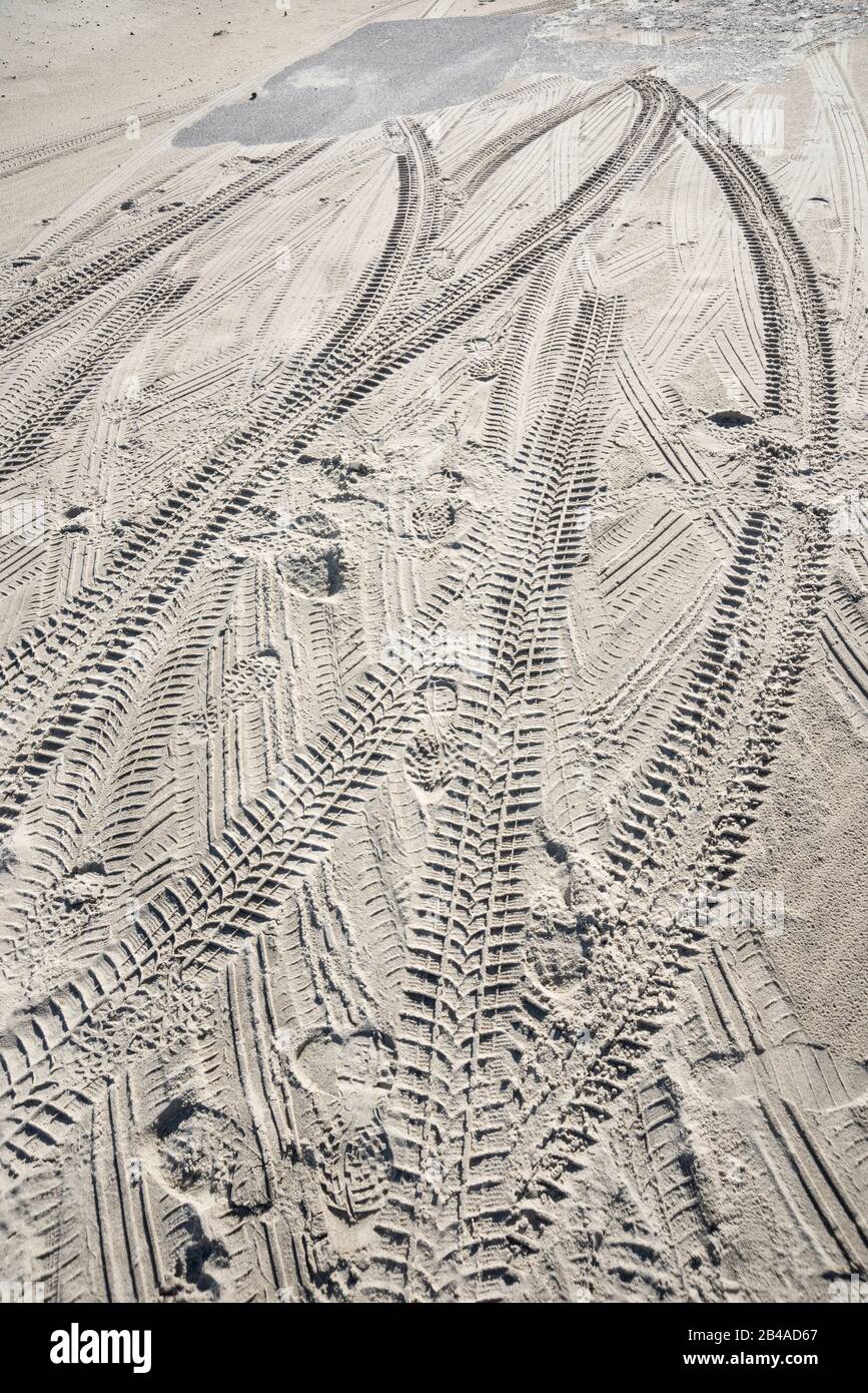 Tyre tracks and footprints in sand Stock Photo
