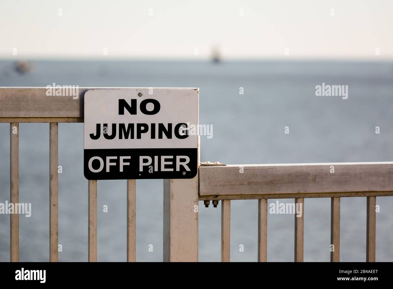 Sign with text No jumping off pier on aluminum railing Stock Photo Alamy
