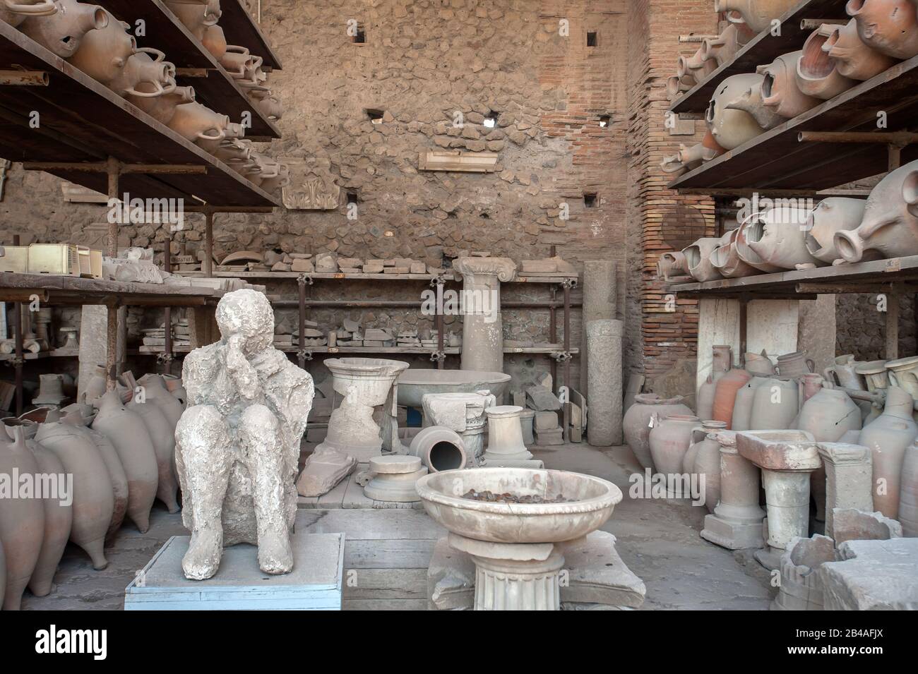 Plaster cast of the body of 'the Muleteer' surrounded by broken pottery in the former Forum Granary at Pompeii, Italy Stock Photo