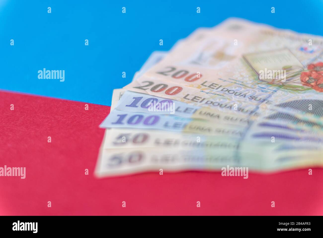 Romanian banknotes on a blue and red background. Coloseup of RON, Romanian Currency. Romanian RON, Lei Banknotes issued by BNR, National Bank of Roman Stock Photo