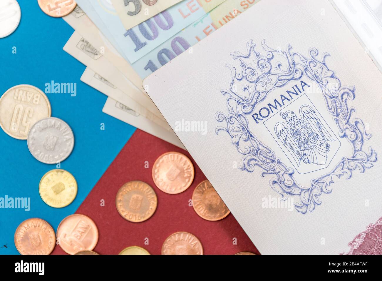 Romanian concept. The Romanian passport and Romanian banknotes/coins on a blue and red background. Coloseup of Romanian Passport and Romanian currency Stock Photo