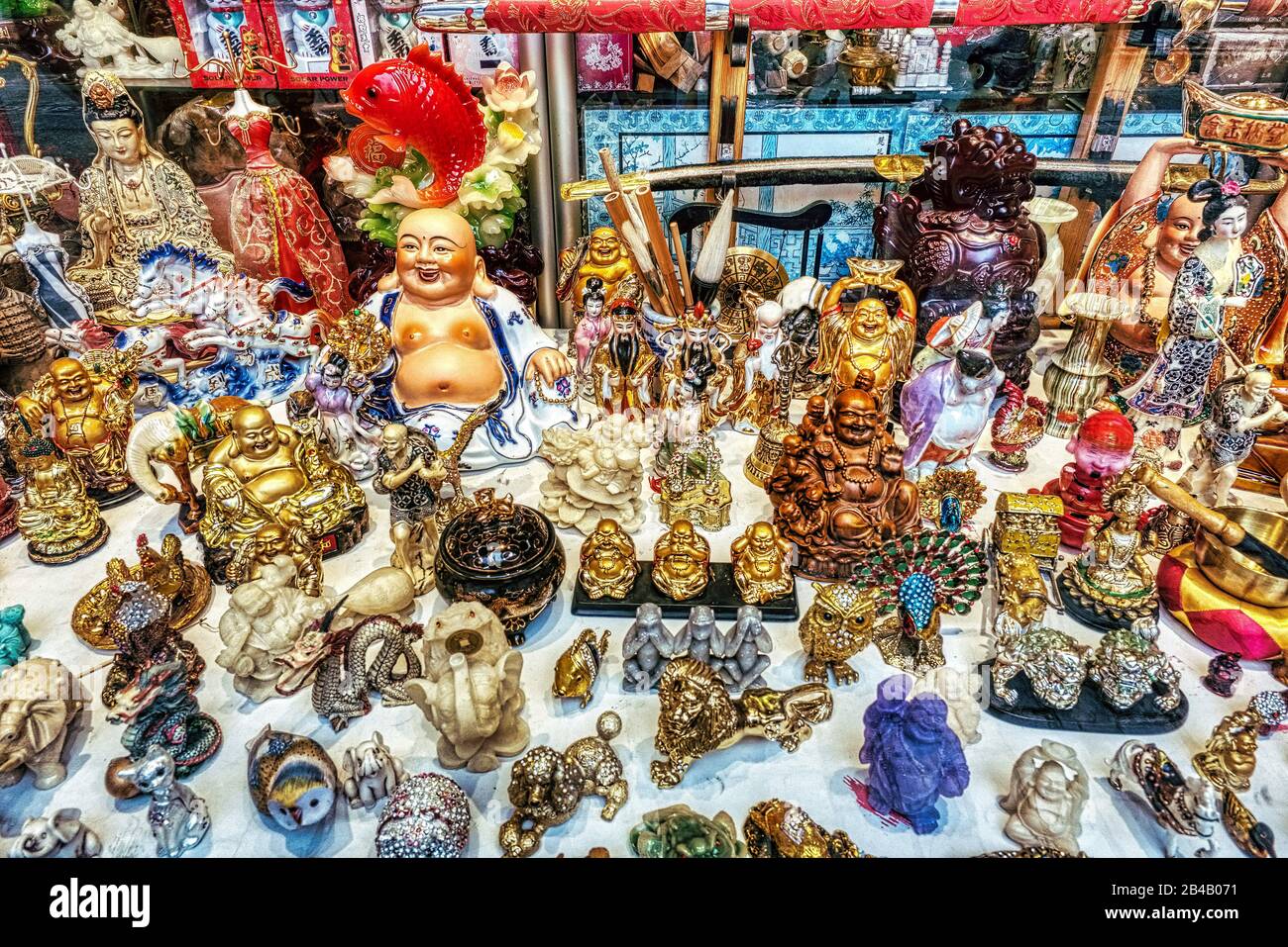 Chinese toys and Buddhas on display in a window in Stockholm Stock Photo