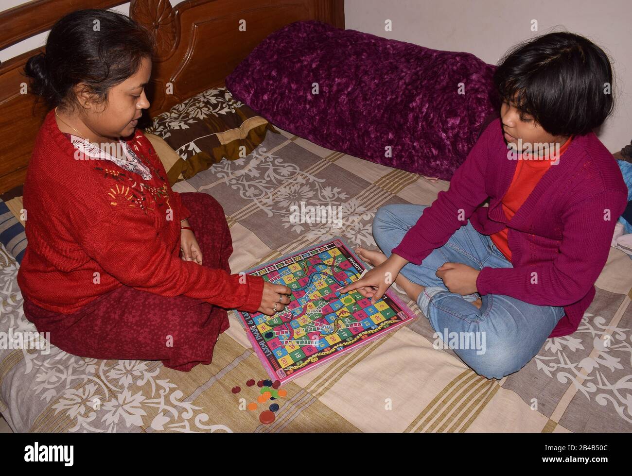 Ludo Game - Indian girl playing ludo with her mother Stock Photo
