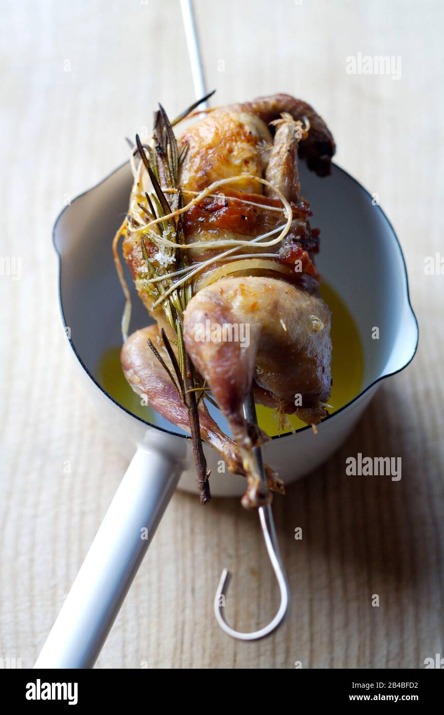 Whole grilled quail with smoked bacon with aromatic herbs Stock Photo