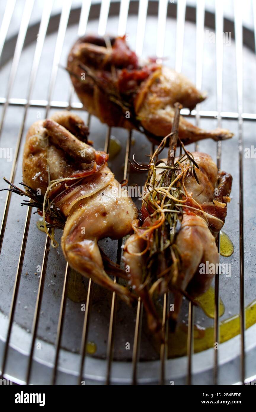 Whole grilled quail with smoked bacon and aromatic herbs Stock Photo