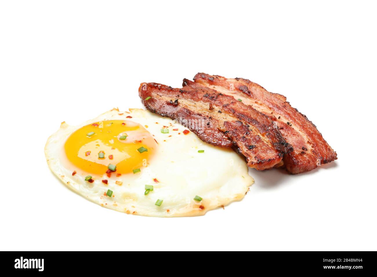 Fried eggs and bacon with spices isolated on white background Stock ...