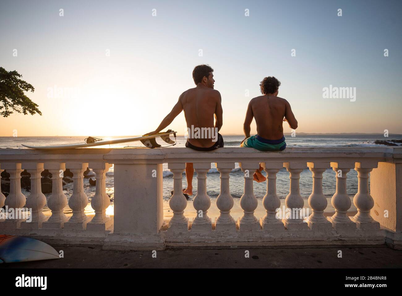 Brazil, state of Bahia, Salvador de Bahia, at sunset two surfers take a break on the seaside Stock Photo