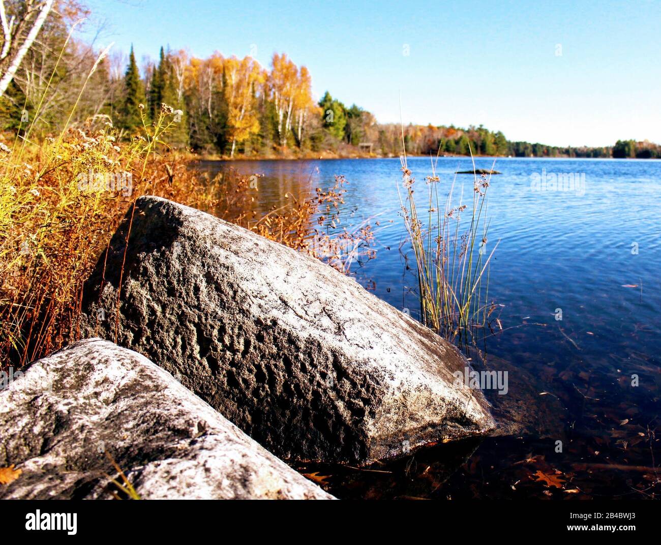 large rocks at edge of peaceful lake Stock Photo - Alamy