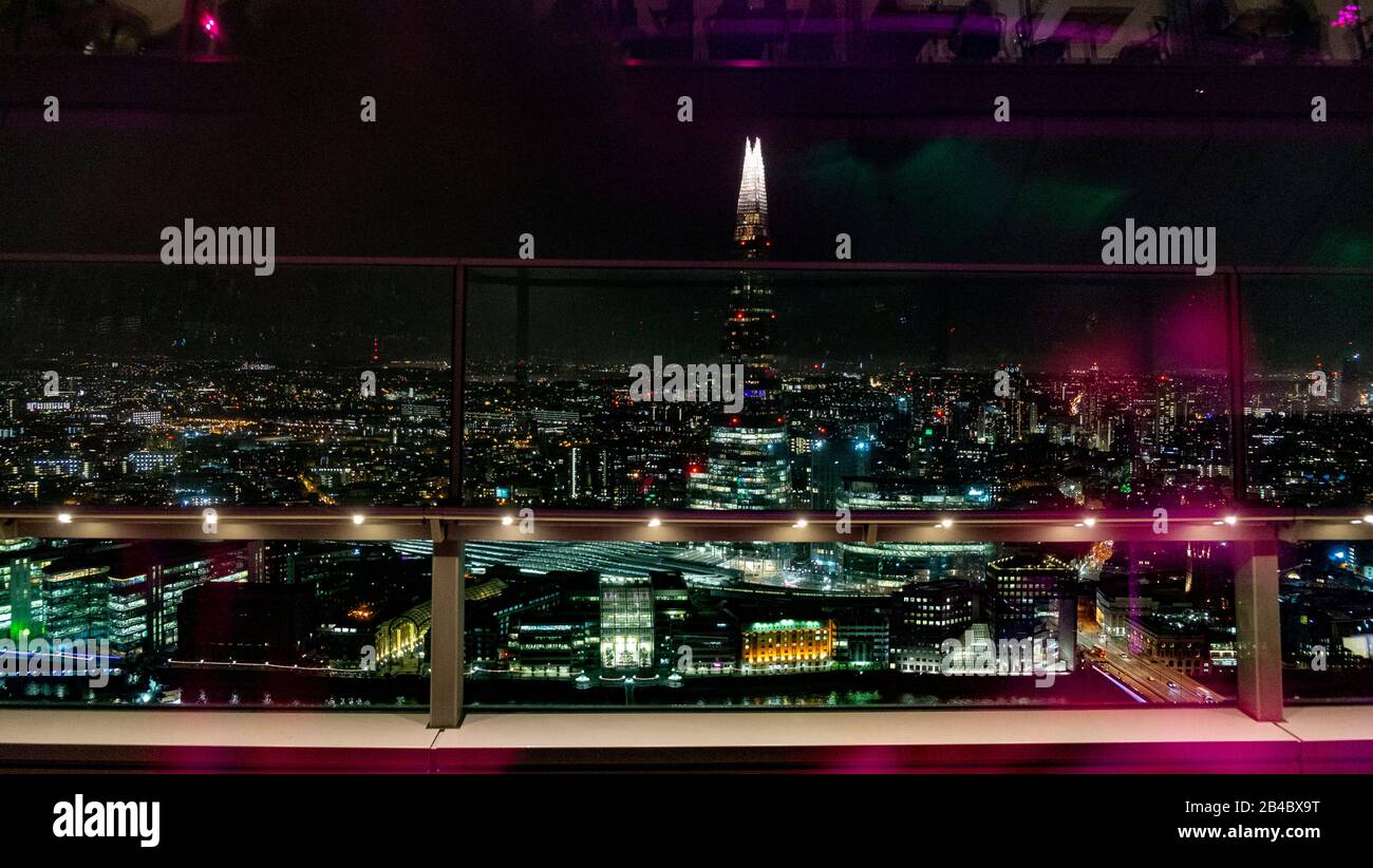London at night as seen from "The Sky Garden" level of floor 35 from 20 Fenchurch Street skyscraper.  Reflections in the glass of the bar area and visitors mix with the city lights giving a surreal look.          by Gavin Crilly Photography, NO SALES, NO SYNDICATION contact for more information mob: 07810638169 web: www.pressphotographergloucestershire.co.uk email: gavincrilly@gmail.com    The photographic copyright (© 2015) is exclusively retained by the works creator at all times and sales, syndication or offering the work for future publication to a third party without the photographer's kn Stock Photo