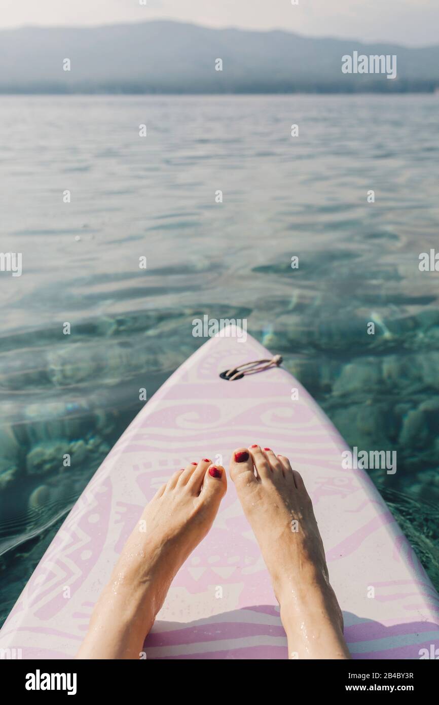 Blickvom Surfbrett über Füße zum Bug ins Wasser, Kroatien Stock Photo