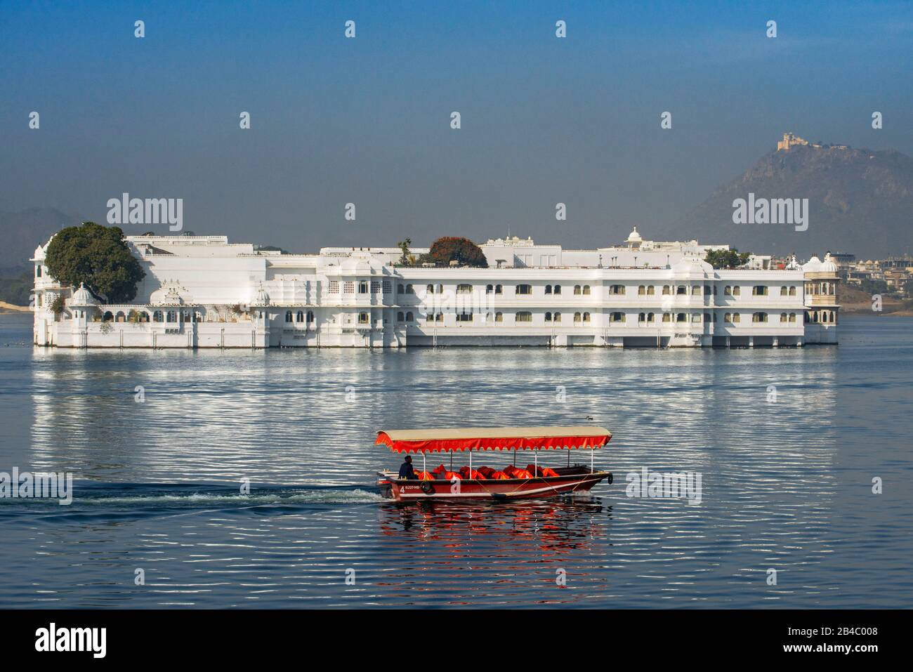 Boat crossing the Lake Palace Hotel Jag Niwas in the middle of Lake Pichola Udaipur Rajasthan India. This is one of the excursion of the Luxury train Stock Photo