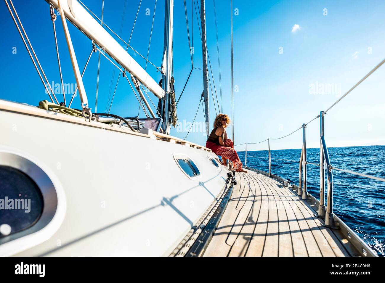 Cheerful happy people enjoying a sail boat trip during outdoor leisure activity and summer