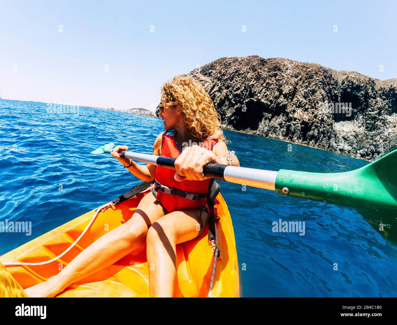Happy beautiful woman in outdoor leisure activity doing kayak trip at the ocean - enjoying summer holiday vacation with sport active people - summer holiday vacation concept Stock Photo