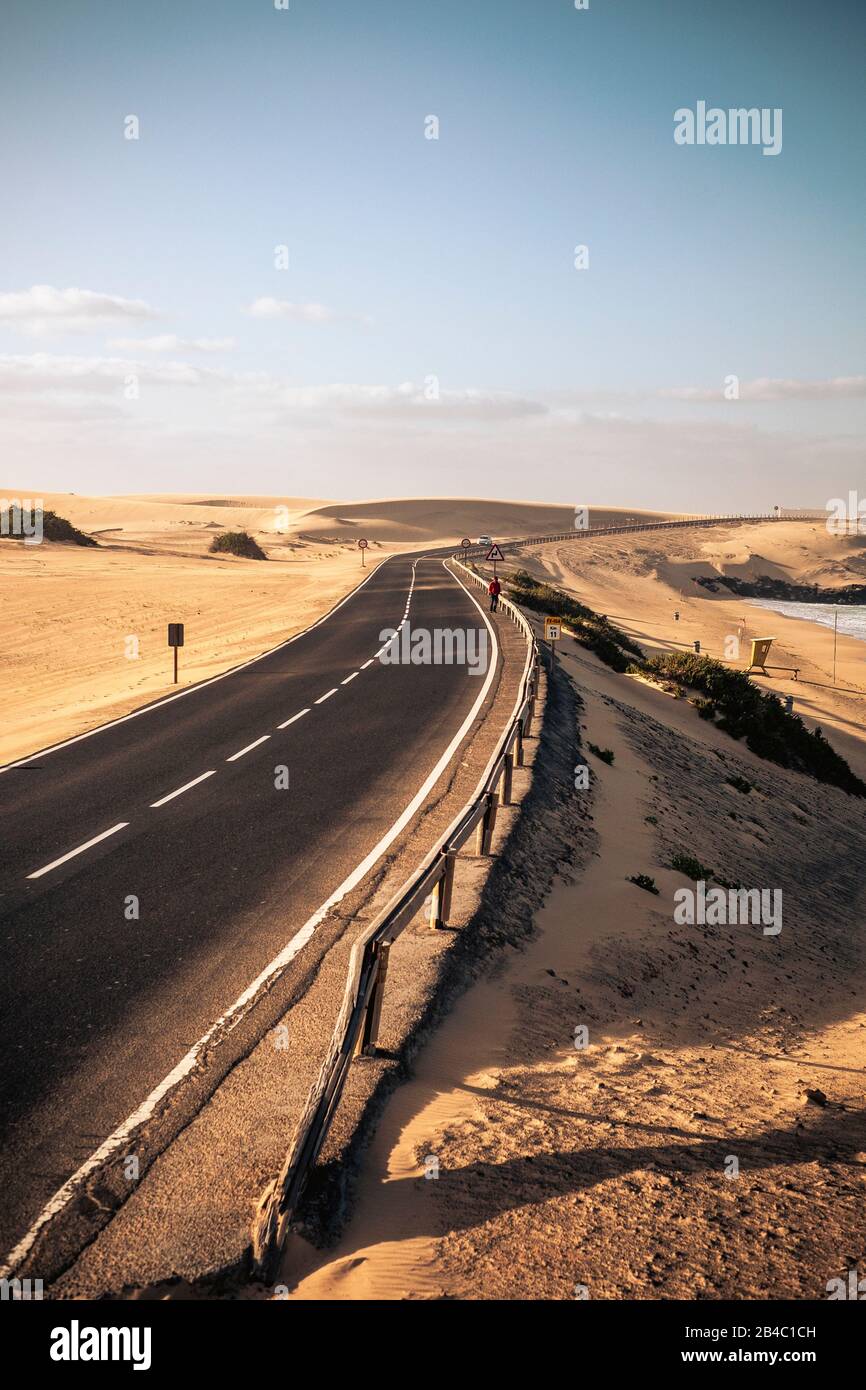 Long black way road in the desert with beautiful beach on the side - concept of travel and summer adventure alternative vacation in tropical beautiful scenic place - blue sky in background Stock Photo