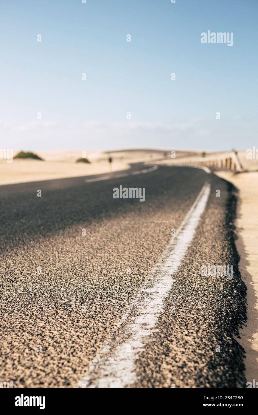 Ground point o view of asphalt long road in the outdoor desert nature - concept of travel and adventure - transportation image in african torpical place - blue sky in background Stock Photo