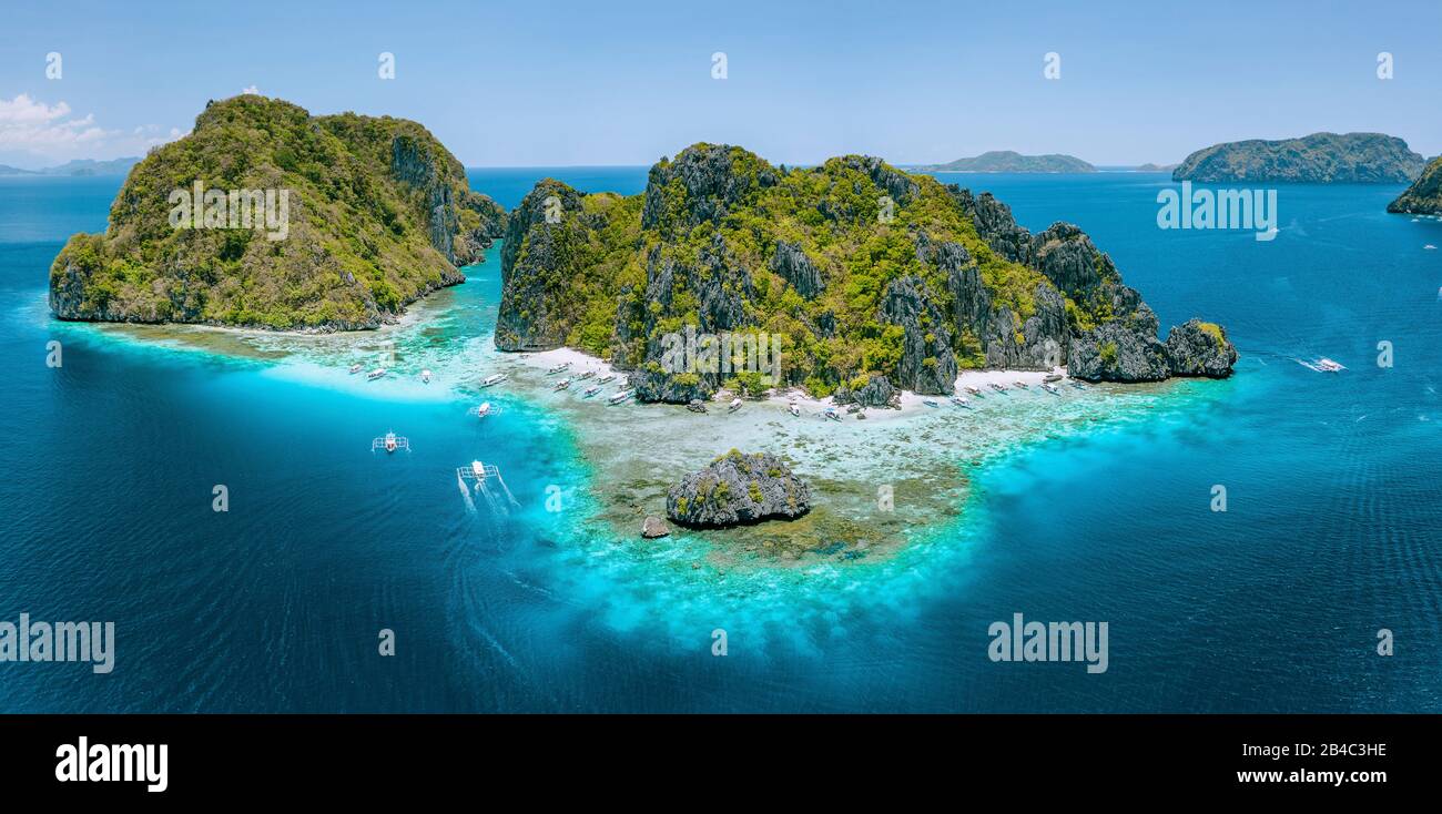 Aerial drone view of tropical Shimizu Island steep rocks and white sand beach in blue water El Nido, Palawan, Philippines. Tourist attraction most beautiful famous nature spot Marine Reserve Park. Stock Photo