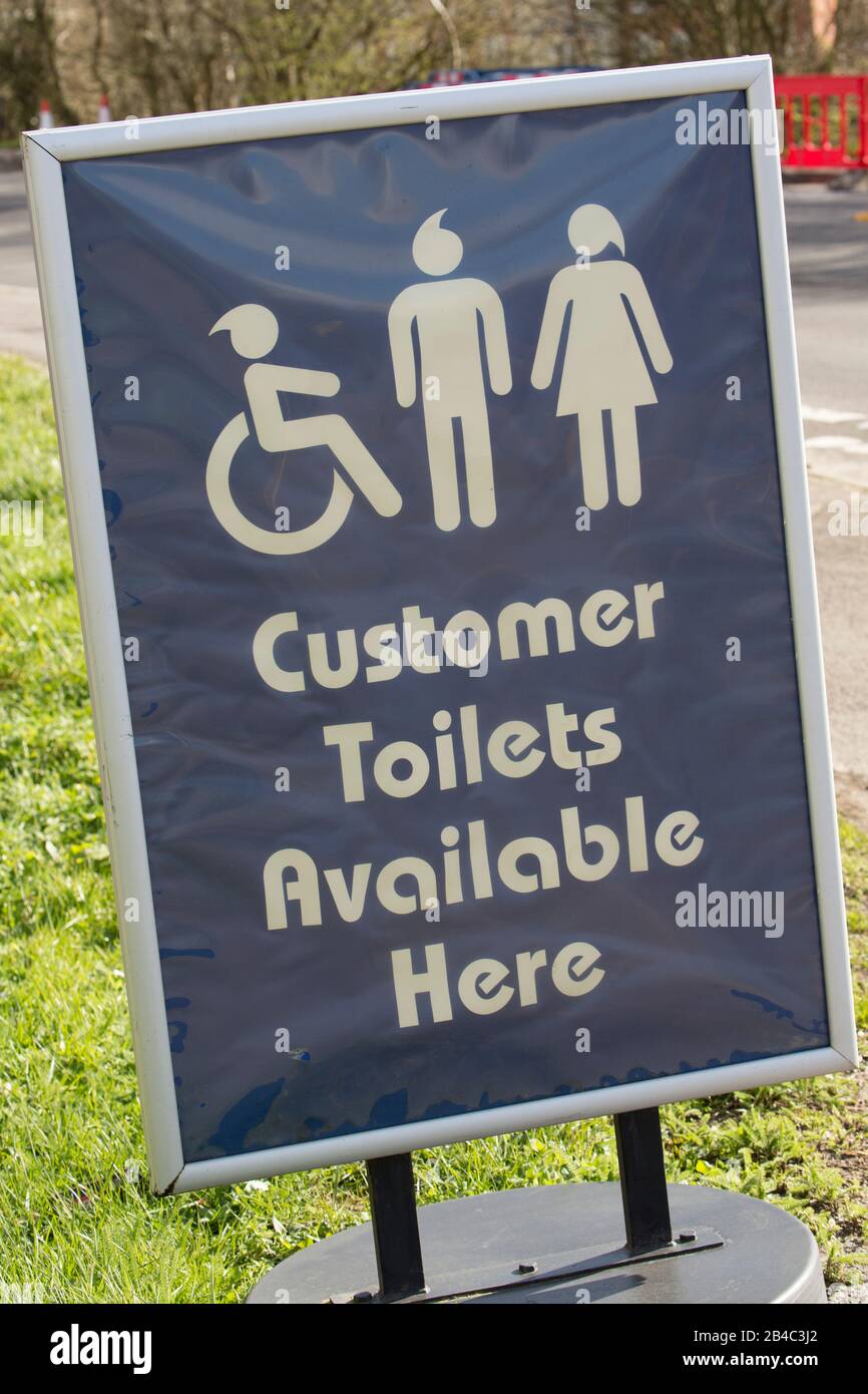 A sign advertising toilets for customers outside an Esso fuel station. Dorset England UK GB Stock Photo