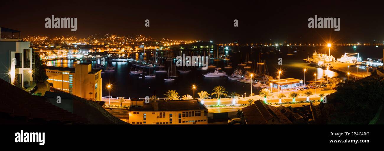 Panoramic night picture of Mindelo city in twilight. Port town with many boats in the lagoon on the Cape Verde, Sao Vicente Island. Stock Photo