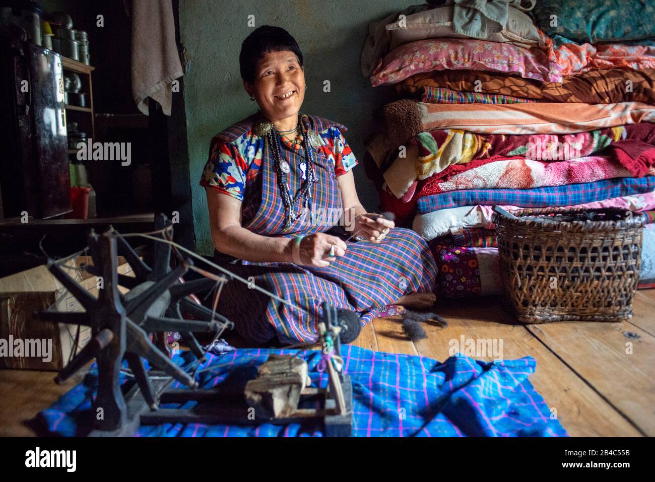 Lobesa village Punakha Bhutan A woman sewing clothes inside her house. Stock Photo